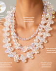 Woman wearing the Alana Cloud statement necklace with clustered iridescent bubbles and a faceted beaded strand.