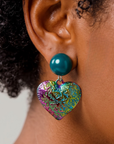 Close up of Amora Pearl Heart Dangle showing teal pearl stud and embossed rainbow heart design.