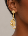 Elegant gold tone swan earrings designed with crystal covered bodies, layered pearl wings, and dangling teardrop pearls.