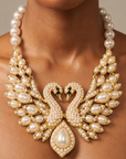 Ornate gold tone swan bib necklace with pavé crystal detailing, pearl embellished wings, and a large teardrop pearl centerpiece.