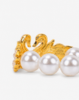 Gold swan statement bracelet designed with mirrored crystal swans, layered pearl wings, and oversized ivory pearl beads