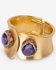 Wide gold cuff bracelet featuring oversized purple stones surrounded by sparkling crystal accents.