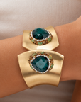 Sassy Jones Armana Emerald statement cuff featuring green stone details, crystal borders and textured gold accents.