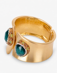 Wide gold cuff bracelet featuring oversized emerald green stones surrounded by sparkling crystal accents.