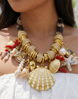 Statement charm necklace featuring pearl-studded shell pendants, coral accents, starfish charms, seashell details, pavé crystal elements, and gold-tone hardware by Sassy Jones.