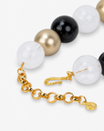Close-up of Chrysallis chunky bead necklace with black, clear, and brushed gold beads and a natural stone pendant.
Black gold and clear chunky necklace featuring an organic agate centerpiece and adjustable chain closure.