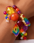 Multicolor bracelet stack featuring red, yellow, orange, purple, and rainbow beads with natural agate accents.