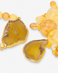 Close-up of Chrysallis Lemon Sorbet bracelets with marbled beads, faceted accents, dangling charms, and sliced agate.
1. Chunky yellow bracelet stack featuring natural stone variations, citrus colored beads, and decorative hanging accents.
