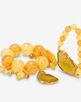 Yellow statement bracelet stack featuring oversized citrus colored beads, dangling accents, and natural agate.