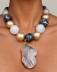 Natural stone statement necklace featuring a gray and black agate slice edged in a Gold tone finish.