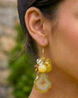 Yellow agate slice statement earrings featuring marbled lemon beads, faceted accents, gold trim, and dangling citrus-inspired details by Sassy Jones.