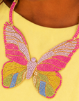 Statement butterfly bib necklace featuring vibrant multicolored crystals in coral, pink, gold, turquoise, and emerald with gold tone detailing.