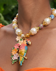 Kalani Pearl Chain necklace featuring oversized pearls, colorful floral beads, gold tone details and a hand painted tropical parrot pendant surrounded by flowers.