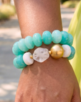 Kamaria Riviera Teal hoop earrings featuring sculptural turquoise beads with small gold colored accents.