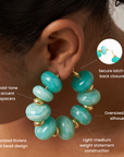 Kamaria Coconut Shell Statement Hoops in Riviera Teal featuring oversized marbled teal coconut shell pieces and gold accents.