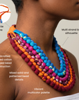 Sassy Jones Kenza necklace featuring cascading strands of colorful textile wrapped beads and an orange fabric tie.