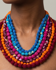 Multistrand textile necklace featuring colorful fabric wrapped beads and adjustable orange cloth ties.