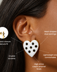 White heart stud earrings decorated with seven black crystals and delicate gold detailing.