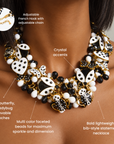 Black and white statement bib necklace featuring whimsical enamel inspired insects, hearts and 18K gold plated accents.