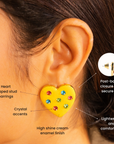 Yellow heart statement stud earrings featuring red, blue and green crystal embellishments with polished gold edging.