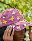 Pink distressed denim ballcap featuring removable butterfly, ladybug, heart, and floral crystal brooch pins by Sassy Jones.