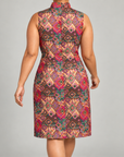 Woman wearing the Sassy Jones Margaux Shift Dress with a colorful pink, green, orange and gold geometric pattern.