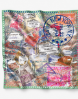 Sassy Jones Charis Jetset Scarf featuring a 51 inch square design with layered immigration stamps and destination graphics.