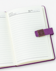Purple affirmation journal featuring white script lettering, decorative gold colored clasp and coordinating pink pens.
