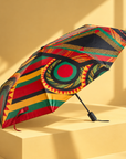 Sassy Jones Afrikaan Umbrella featuring vibrant red, green, yellow and black geometric patterns.