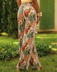 Women's silky pleated wide leg floral pants featuring a watercolor botanical print in sage, terracotta, blush, and cream with a comfortable pull on waistband.