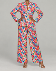 Summer Garden floral jacket shown on model with long sleeves, structured tailoring, and vivid painterly flowers.