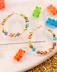 Colorful glass bead and pearl hoop earrings with gold accents designed for playful luxury styling