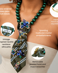 Statement necktie necklace featuring glossy green beads, a printed fabric tie and removable jeweled embellishments.