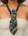 Statement necktie necklace featuring glossy green beads, a printed fabric tie and removable jeweled embellishments.