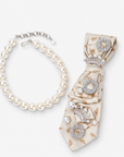 Sassy Jones Pearl Queen necktie necklace featuring cream fabric with delicate gold floral patterns and ornate crystal brooches.