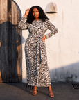 Women's black and ivory zebra print relaxed midi dress featuring a removable wrap tie waist, long sleeves with slit cuffs, and an elegant flowing silhouette.
