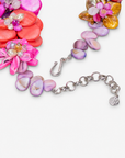 On model view of colorful Wisteria floral necklace featuring dimensional shell flowers, pearl centers and delicate gold colored details.