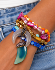 Colorful five piece stretch bracelet set featuring layered shell beads, metallic gold accents, and two dimensional shell charms.
