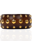Brown honeywood inspired statement bangle bracelet with gold dome stud embellishments on a white background.