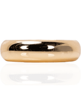 Glossy champagne gold resin bangle bracelet with smooth rounded silhouette on a white background.