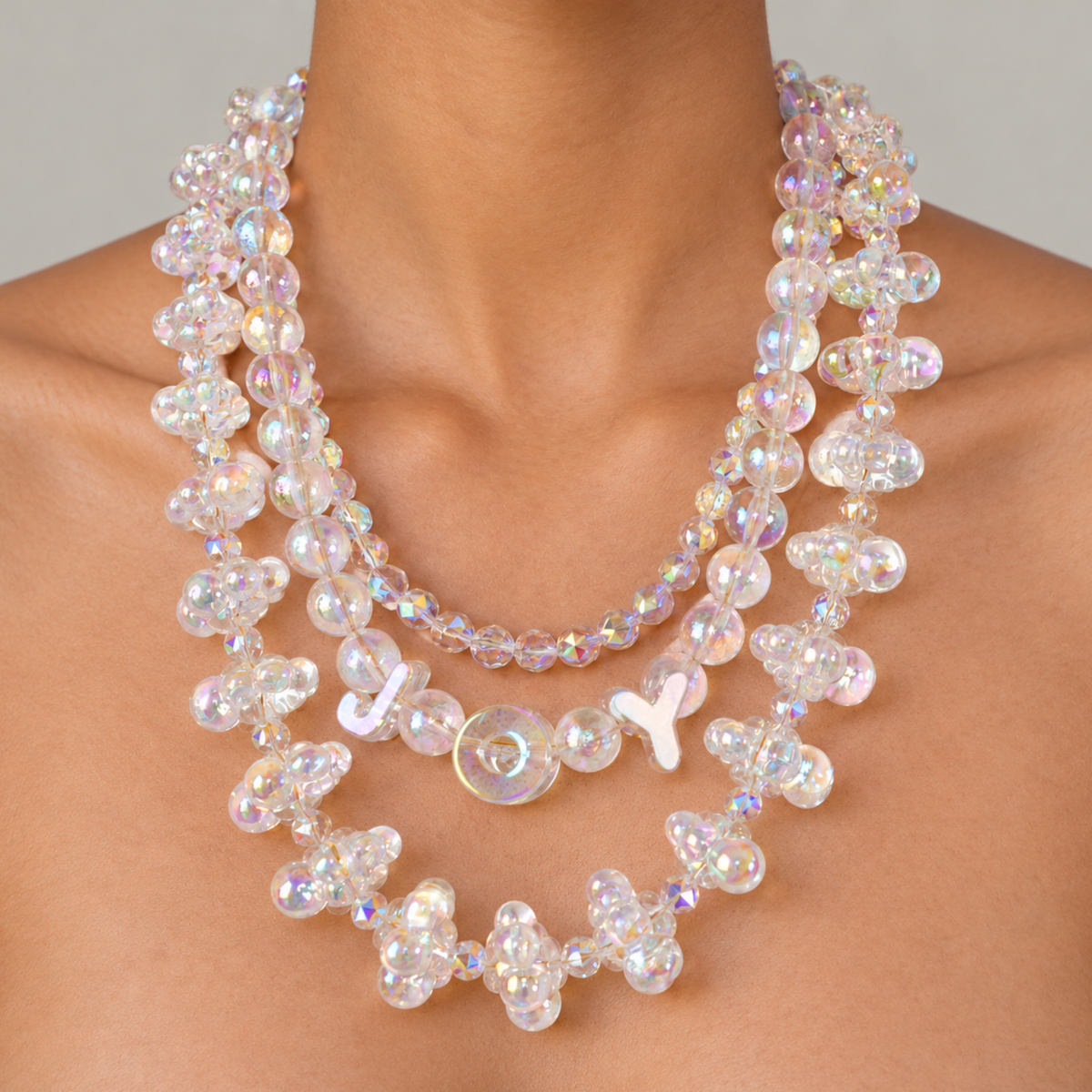 Sassy Jones Alana Cloud Bubble Chain featuring clear dimensional beads reflecting pink, lavender, blue and gold tones.
