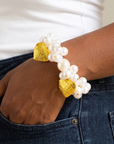 Amora bracelet shown on model with mixed size ivory pearls and two oversized textured heart charms.