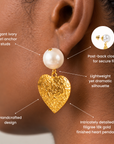 Ivory pearl statement earrings featuring dangling gold hearts with intricate embossed floral detailing.