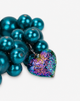 Chunky teal pearl statement bracelet featuring multicolor iridescent hearts in pink, green, blue and gold tones.