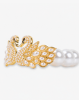 Dramatic swan and pearl bracelet featuring crystal covered gold tone birds, luminous ivory pearls, and an elegant statement design.