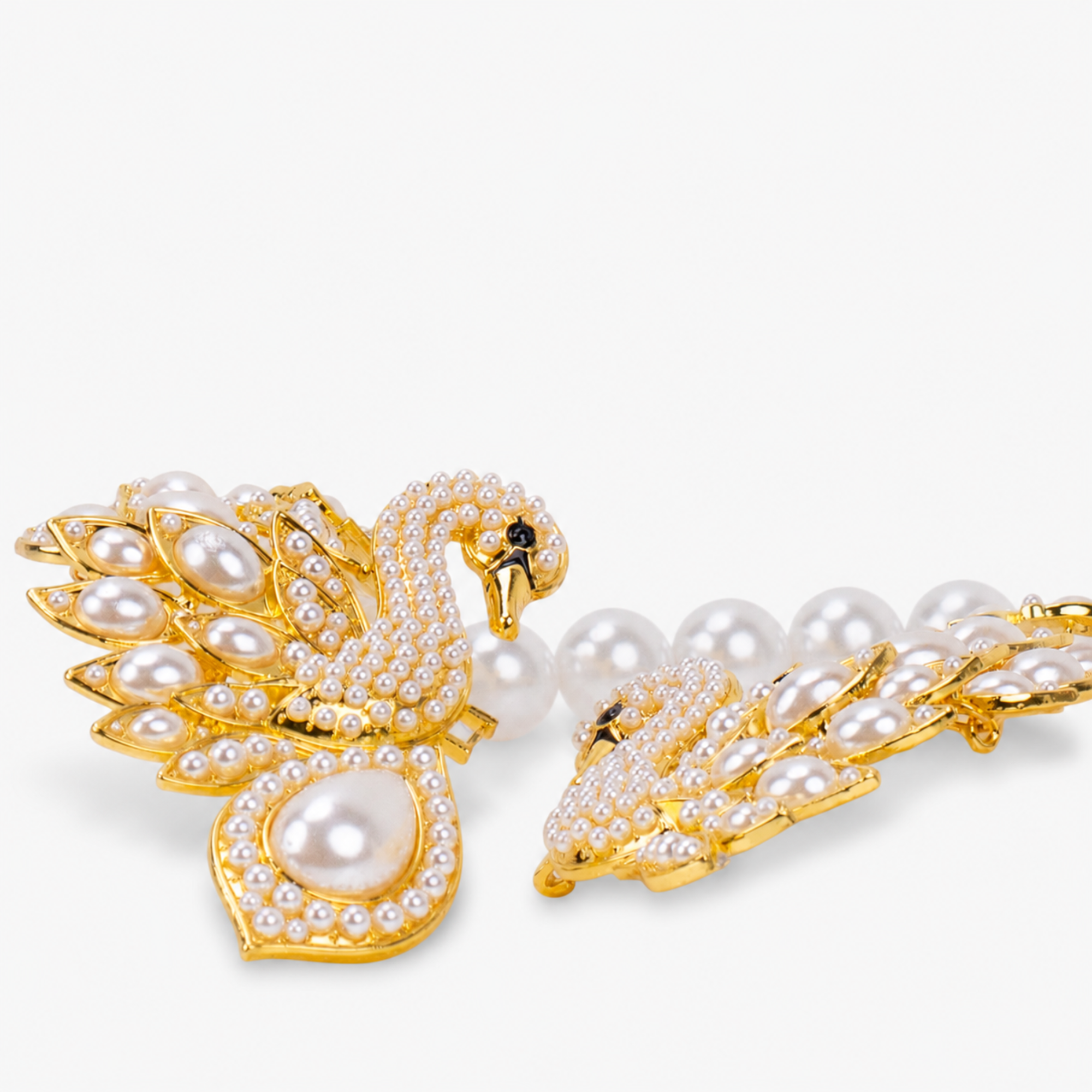Gold swan statement necklace embellished with sparkling crystals, ivory pearl accents, and an elegant double swan centerpiece.