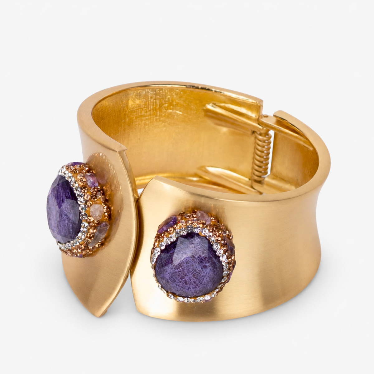 Wide gold cuff bracelet featuring oversized purple stones surrounded by sparkling crystal accents.