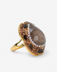 Black statement ring featuring a dark stone centerpiece surrounded by sparkling crystals and Gold tone finish.