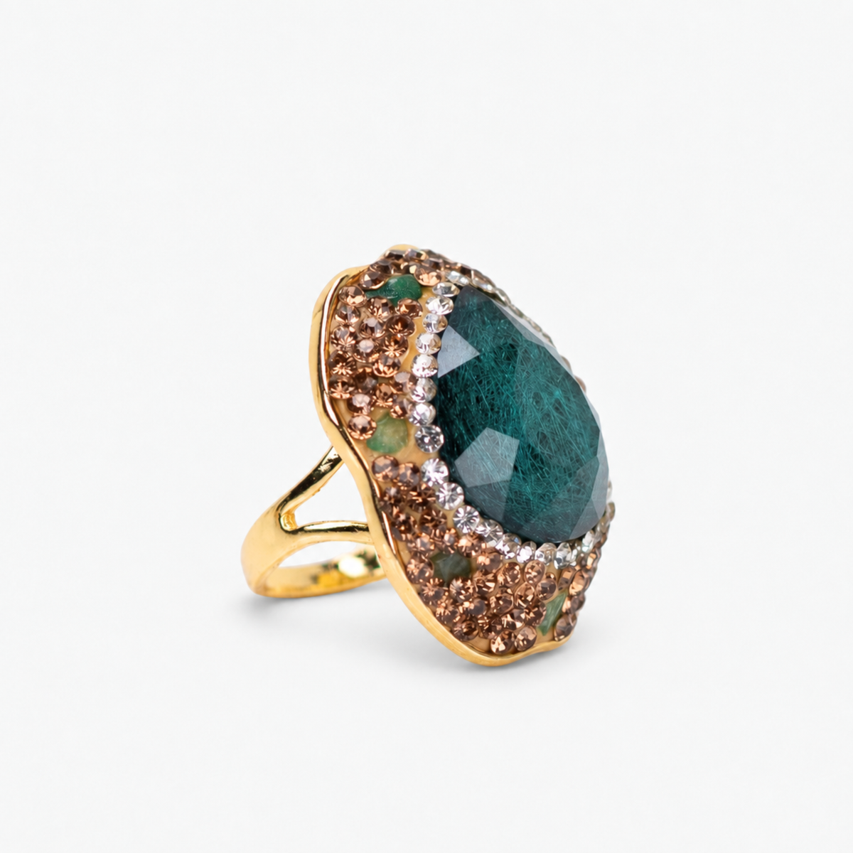 Emerald green statement ring featuring an organic stone surrounded by crystals and a Gold tone finish.