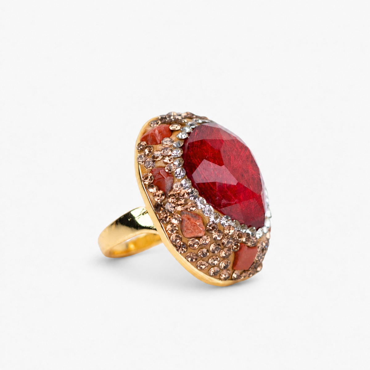 Red statement ring featuring a rich faceted stone surrounded by crystals and a Gold tone finish.